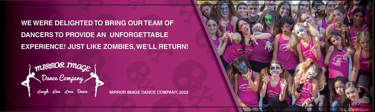 A large group of dancers in pink tops and zombie face paint pose together.