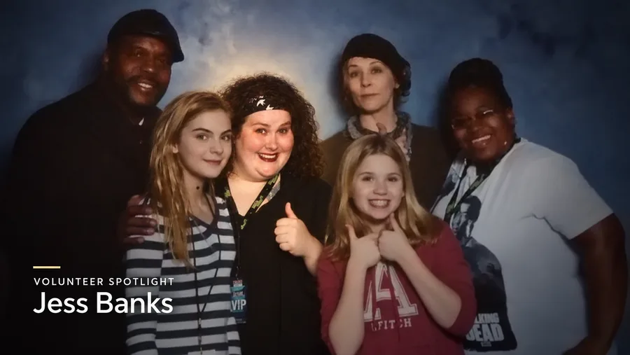 A spotlight graphic captioned Volunteer Spotlight, Jess Banks, over a convention photo of six people posing together, smiling and giving thumbs up.