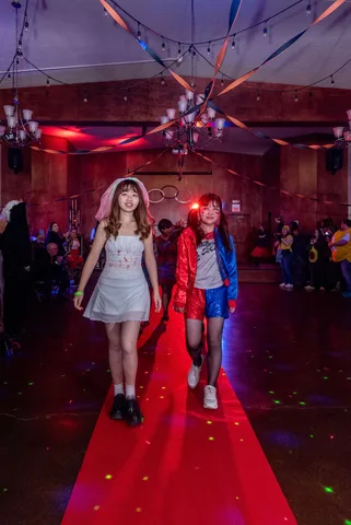 A zombie bride and a friend in a red and blue costume walk the red carpet together.