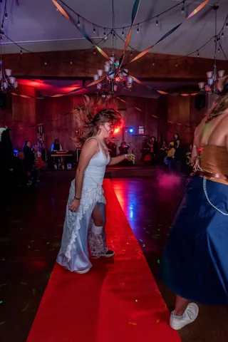 Two women in costume dance together on the ballroom floor.