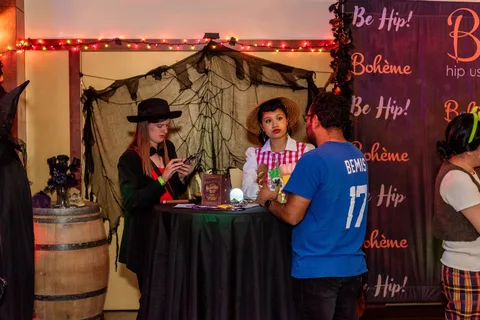 Guests visit a fortune teller booth with a crystal ball and tarot props.