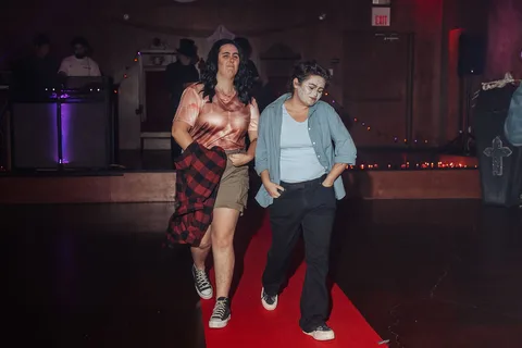 Two women are caught mid-motion walking the runway, blurred.