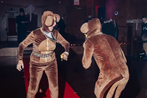 Two guests in furry animal costumes dance together.