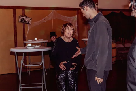 Two guests talk candidly near a small cocktail table.