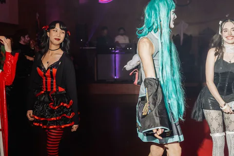 Two women, one in a green ivy costume, stand on the runway.