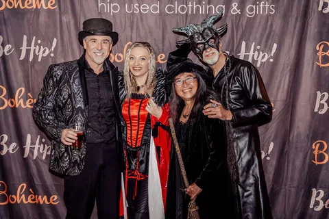 A group in costume poses together in front of the Boheme clothing shop backdrop.