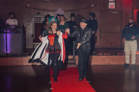 Costumed guests gather on the red carpet runway.