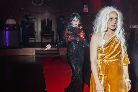 The two gowned women continue down the runway together.