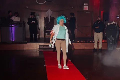 The mad scientist costumed woman stands calmly at the end of the runway.