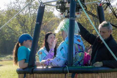 A woman laughs mid-conversation with fellow riders in the hot air balloon basket.