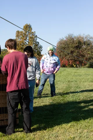 Three guests stand and chat on the cemetery lawn.