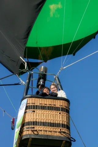 Two riders in the basket look outward past the Davis Food Co-op banner.
