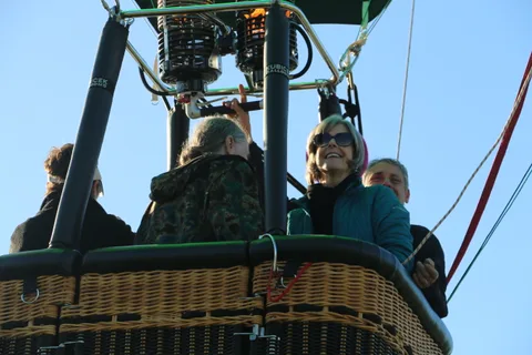 Two riders stand close together in the basket.