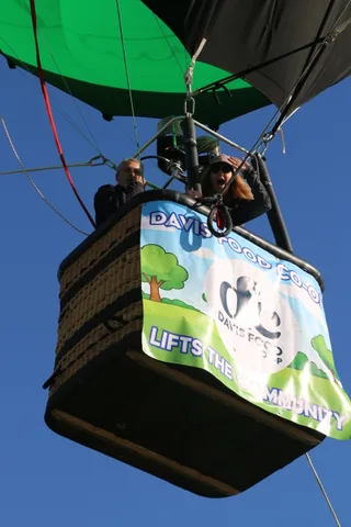 A cropped close view of the Davis Food Co-op sponsor banner on the balloon basket.