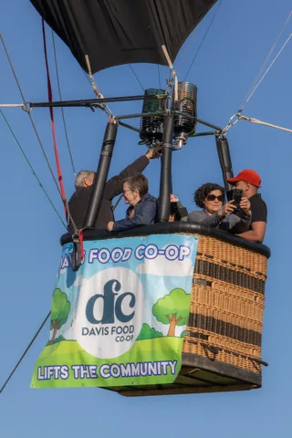 A man and woman pose for a phone photo together in the basket.