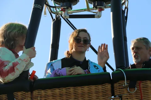 Riders in costume talk together in the basket.