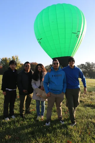 The second group poses again for the camera with the balloon above.