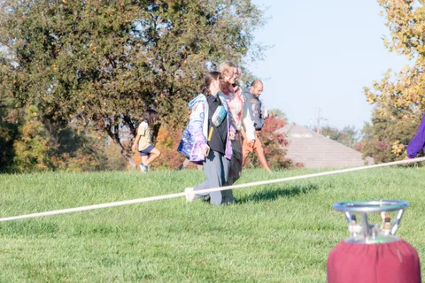 A wide, quiet view of the grass field with distant figures near a line laid on the ground.