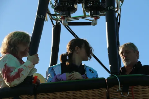 A costumed rider exchanges something with another passenger.