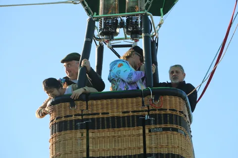 Riders wait in the basket as the burner glows above them.