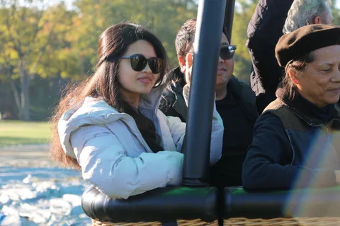 A woman in sunglasses leans against the basket rail.
