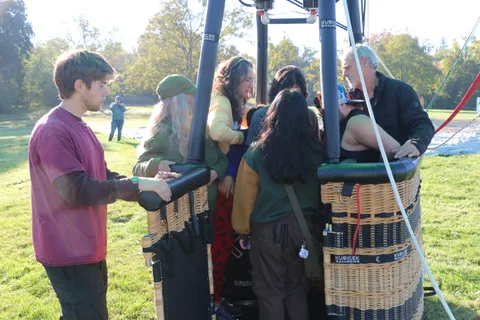 A man hands something to a rider standing beside the basket.