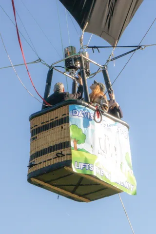The burner mechanism crowds the top of the frame above two riders.