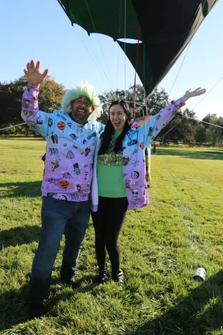 A couple raises their arms in celebration while another guest walks by in the background.