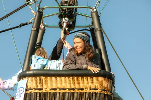The same woman and blanket-wrapped child wave again a moment later.