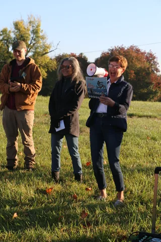 Three attendees chat casually on the lawn before the launch.