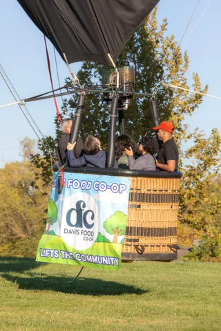 Several riders peek over the rim above the full Davis Food Co-op banner.