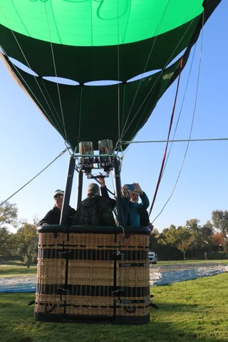 A rider takes a photo while others stand nearby in the basket.