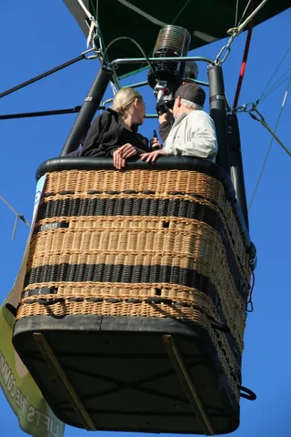 Two men stand together in the basket.