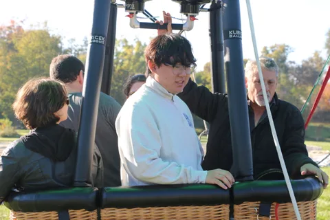 A teenager talks with an older man in the basket.