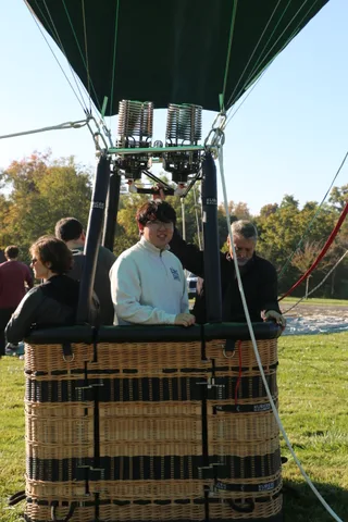 The group waits together in the basket in clear light.