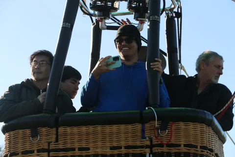 Two riders check a phone camera in the basket.