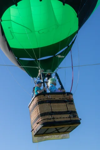 A close, minimal view of the bottom of the green balloon envelope.