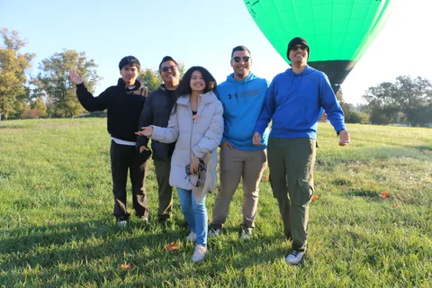 The group laughs together as they pose for another shot near the balloon.