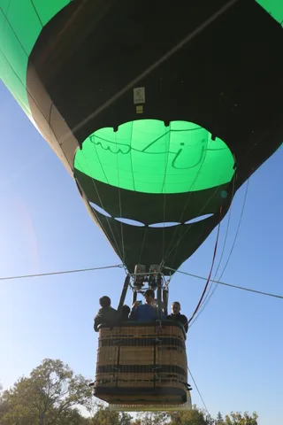 The balloon continues rising over the park.
