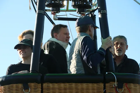 A group of men in caps talk together in the basket.