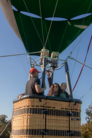 A man in a black shirt and a woman in sunglasses stand together at the basket edge.