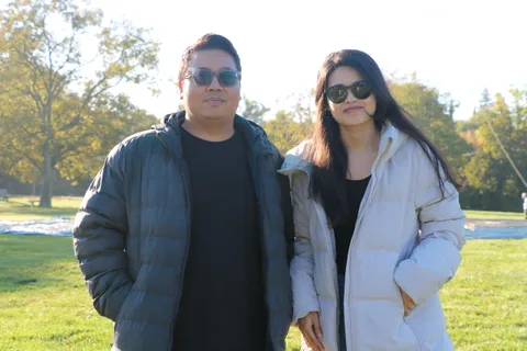 A couple in sunglasses poses together on the lawn after the ride.