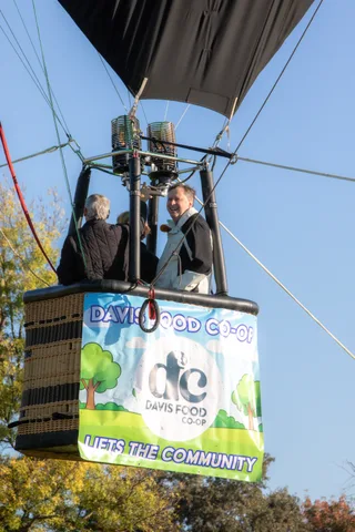 The basket continues rising with the Davis Co-op banner visible, no riders in view.