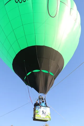 The dark underside of the balloon arcs over the distant basket.