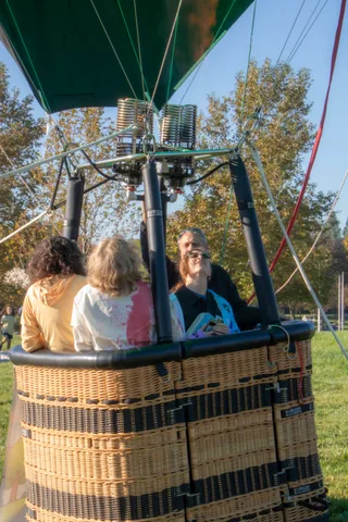 A mixed-age group sits and stands around the grounded basket.