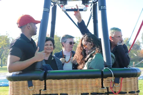 A man in a red cap raises his arm as the group cheers in the basket.