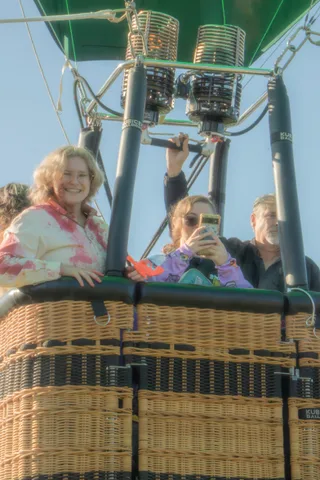 A woman flashes a bright genuine smile straight at the camera from the basket.