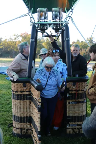 Riders look up at the burner flame from inside the balloon basket.