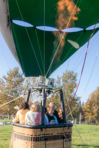 A few guests stand near the basket on the ground.