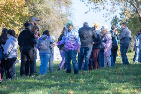 A crowd gathers near a face painting tent sign.